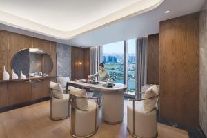 un uomo che si trova su un'isola della cucina in una stanza con vista di Oakwood Residence Foshan a Foshan