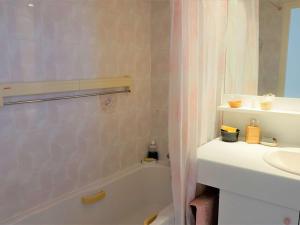 ein Badezimmer mit einer Badewanne, einem Waschbecken und einem Duschvorhang in der Unterkunft Appartement Perros-Guirec, 2 pièces, 4 personnes - FR-1-368-293 in Perros-Guirec