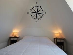 a bedroom with a large clock on the wall at Maison Perros-Guirec, 3 pièces, 4 personnes - FR-1-368-301 in Perros-Guirec