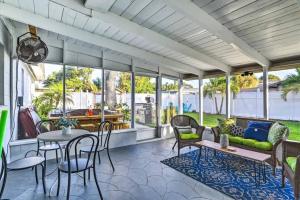 une terrasse couverte avec une table et des chaises dans l'établissement NEW! Cheerful bungalow with hot tub near beaches, à Bay Pines