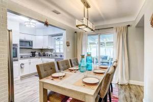 uma cozinha e sala de jantar com uma mesa de madeira e cadeiras em NEW! Cheerful bungalow with hot tub near beaches em Bay Pines