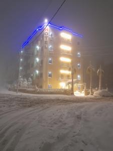 a large building with blue lights on it in the snow at Al Karawan Hotel Apartments in Amman