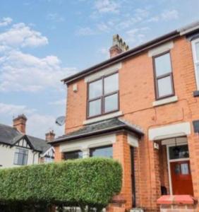 a brick house with a hedge in front of it at Spacious Home - King Size Bed - Pets - In Oak Hill in Trent Vale
