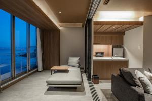 a living room with a couch and a kitchen at AMANE resort SEIKAI in Beppu