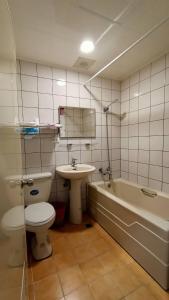 a bathroom with a toilet and a sink and a tub at Xitou Tianpin Homestay in Lugu Lake