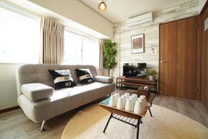 salon z kanapą i telewizorem w obiekcie Tsurigane Building w Osace