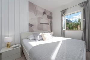 ein weißes Schlafzimmer mit einem Bett und einem Fenster in der Unterkunft Lovely Lucia's house in Dubrovnik + 54 Fotos