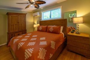 a bedroom with a bed and a ceiling fan at Hideaway Cove Poipu Beach in Koloa