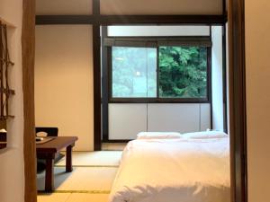 a bedroom with a bed and a window and a table at SyunkaSyuutou - Vacation STAY 53638v in Hakone