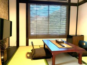 a living room with a coffee table and a tv at SyunkaSyuutou - Vacation STAY 53638v in Hakone