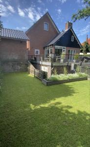 een huis met een groene tuin met een huis bij By Balu in Soest