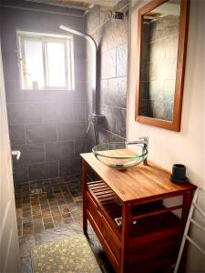 La salle de bains est pourvue d'un lavabo en verre et d'une douche. dans l'établissement Alambic de Grand Anse, à Petite Île
