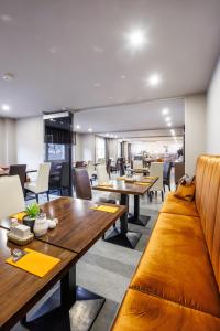 فندق لوتسوف في برلين: غرفة طعام مع طاولات وكراسي خشبية