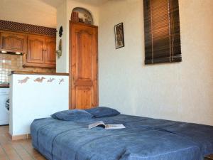 um quarto com uma cama azul com um livro em Appartement Le Lavandou, 2 pièces, 4 personnes - FR-1-251-348 em Le Lavandou