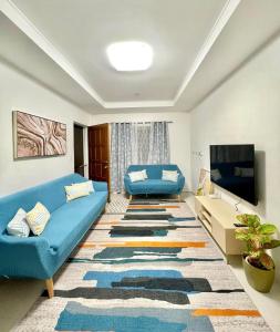 a living room with a blue couch and a tv at Ana's Haven Olongapo/Subic (East Bajac-Bajac) in Olongapo