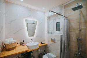 La salle de bains est pourvue d'un lavabo et d'une douche. dans l'établissement new cozy by the sea apartment, à Thessalonique