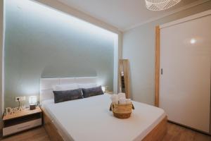 - une chambre avec un grand lit blanc et un panier dans l'établissement new cozy by the sea apartment, à Thessalonique
