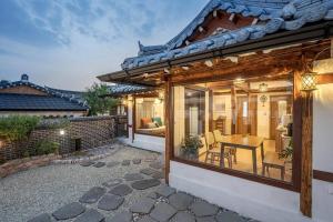 a house with a patio with a table and chairs at Hanokstay Haru in Jeonju