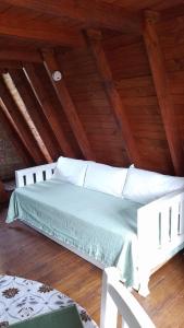 uma cama branca num sótão com tectos em madeira em CABAÑAS COPITL em Tanti