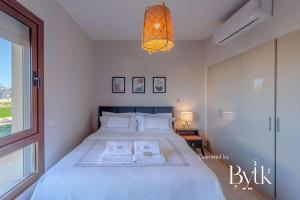 a bedroom with a large white bed and a window at BYTK - La Casa Del Sol in Hurghada