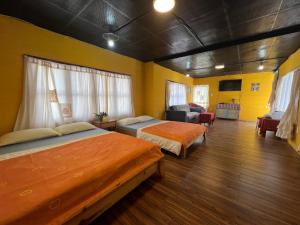 two beds in a room with yellow walls at Hometown & Bungalow in Da Lat