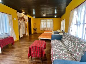 a room with a bed and a couch and a table at Hometown & Bungalow in Da Lat