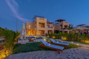 a house on the beach with two lounge chairs at BYTK - La Casa Del Sol in Hurghada
