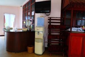 a kitchen with a counter with a refrigerator and a television at โรงแรม พี รีสอร์ท in Kamphaeng Phet