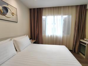 um quarto com uma grande cama branca e uma janela em Link Hotel Singapore em Singapura