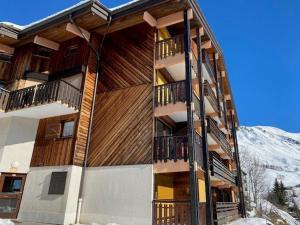 a building with balconies and a snow covered mountain at Studio Le Grand-Bornand, 1 pièce, 6 personnes - FR-1-458-173 in Le Grand-Bornand