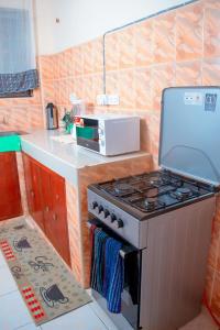 uma cozinha com um fogão e um micro-ondas em 2bedroom classic apartment 2 em Kilifi