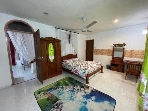 a bedroom with a bed and a table and a mirror at MIA FAMILIA HOMESTAY in Cukai