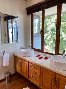 a bathroom with two sinks and two mirrors at Anse Soleil Beachcomber Hotel and Self Catering in Baie Lazare Mahé