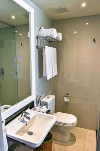 a bathroom with a toilet and a sink and a mirror at Earl's Regent Negombo in Negombo