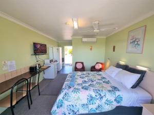 a bedroom with a large bed and a kitchen at Mollymook Ocean View Motel Rewards Longer Stays -over 18s Only in Mollymook