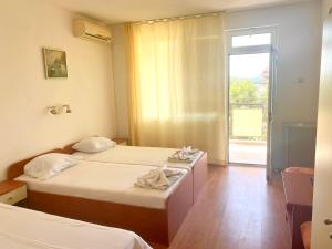 um quarto de hotel com duas camas e uma janela em Къща за гости Стоянови em Primorsko