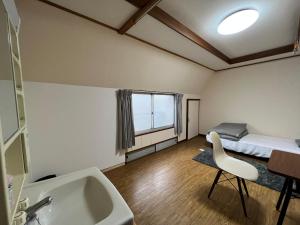 a bathroom with a sink and a bed in a room at HOSTEL OE in Yoshinogawa