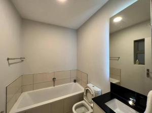 a bathroom with a tub and a toilet and a sink at Spacious Apartment in The Median Rosebank in Johannesburg