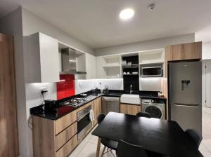 a kitchen with a table and a stove top oven at Spacious Apartment in The Median Rosebank in Johannesburg