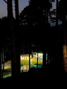a view of a house with a pool in the woods at Nitya Village Retreat in Chamba