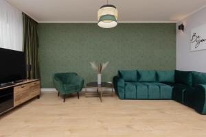 sala de estar con sofá azul y TV en Bemowo Górczewska Apartment by Renters, en Varsovia