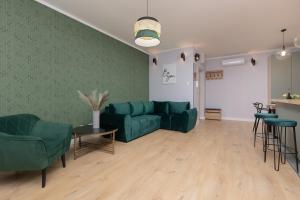 a living room with a green couch and chairs at Bemowo Górczewska Apartment by Noclegi Renters in Warsaw