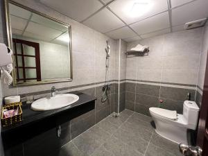 a bathroom with a sink and a toilet and a mirror at Ven Hồ Hotel in Hanoi