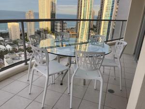 a table and chairs on a balcony with a view of the city at Stunning Apartment Best Ocean Views Surfers in Gold Coast