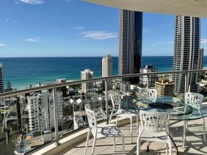 a balcony with a table and chairs and the ocean at Stunning Apartment Best Ocean Views Surfers in Gold Coast