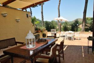 a patio with a table and chairs and an umbrella at Saha tourist accommodation among olive trees and sea view in Sperlonga