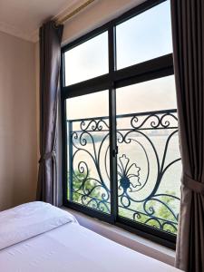 a bedroom with a window with a view of a balcony at Ven Hồ Hotel in Hanoi