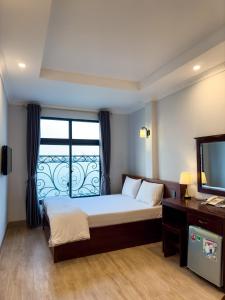 a bedroom with a bed with a window and a television at Ven Hồ Hotel in Hanoi