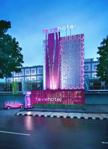 favehotel Langko Mataram - Lombok في ماتارام: مبنى مضاء باللون الزهري والارجواني