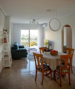 a living room with a dining room table and chairs at Open view Pinetree penthouse in Dehesa de Campoamor